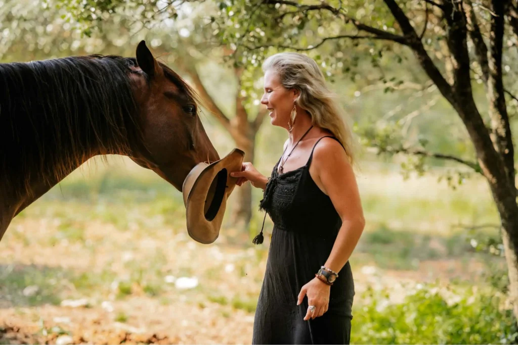 Cypriane Guyot et son cheval qui attrape son chapeau dans sa main